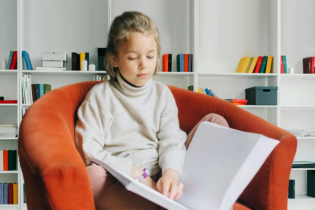IEP guidance for parents with young blind girl sitting in orange chair holding a book