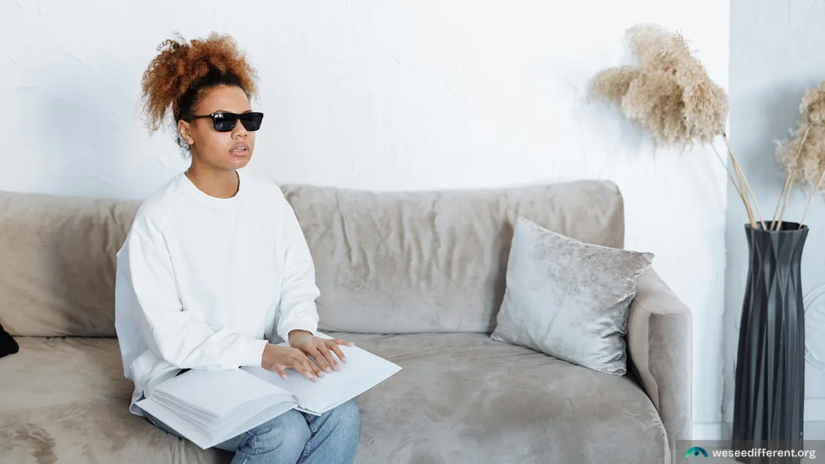 African American woman sitting on gray couch with vision impairment and mental health issues